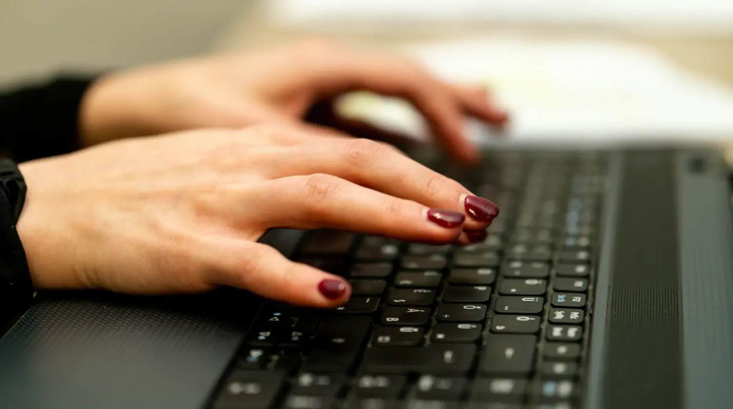 Manos de mujer tecleando en un ordenador