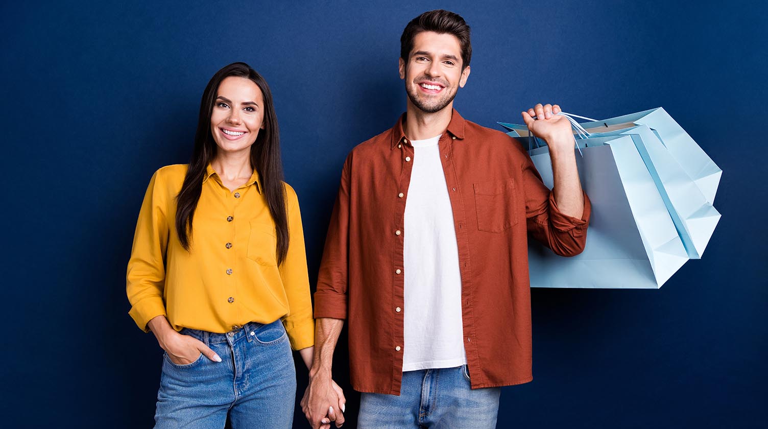 Pareja con bolsas sobre fondo azul